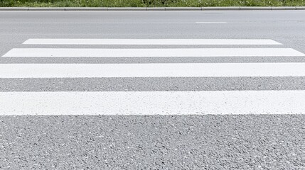 Fototapeta premium White pedestrian zebra crossing stripes painted on a grey asphalt road.