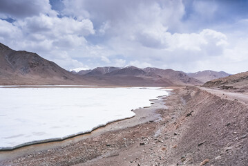 Snow lies in the valley in the highlands of Tien Shan in Pamir in Tajikistan, panoramic landscape for background in high mountains with rocks, snow and glaciers