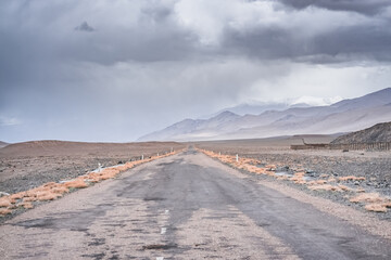 Asphalt road of the Pamir Highway in the valley of the Tien Shan Mountains in Tajikistan in the...