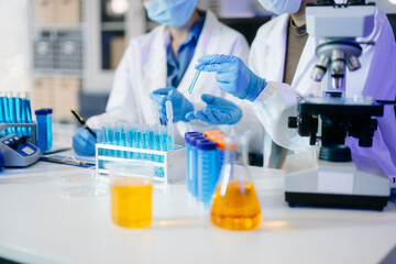 Fototapeta premium Young scientists conducting research investigations in a medical laboratory, a researcher in the foreground