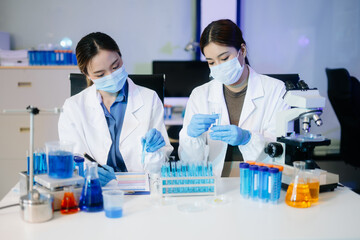 Young scientists conducting research investigations in a medical laboratory, a researcher in the...