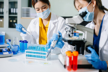 scientists in lab coats conducting research, handling glassware, and working with chemicals