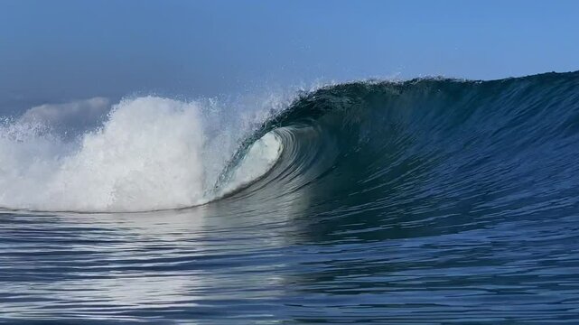 Perfect blue ocean wave breaks on the shore in Indonesia.Slow motion video.View from the water
