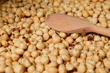 Roasting hazelnuts in a cozy kitchen, enhancing flavors with a wooden spoon on a rustic countertop...