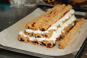 Delicious pastry creation showcasing layers of cream and fruit filling on a bakery counter in the...