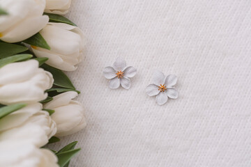 Delicate white flowers beside fresh tulips on a light background