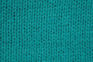 Textured close-up of vibrant turquoise knitting fabric in natural light