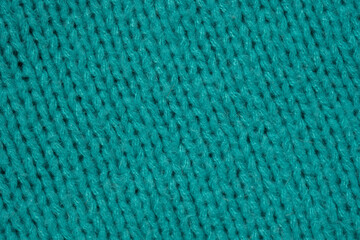 Textured knitted fabric in vibrant turquoise hue displayed closely