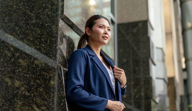 Confident Asian Businesswoman Looking Forward with Determination. Professional Corporate Portrait of Modern Executive in Urban Office Setting