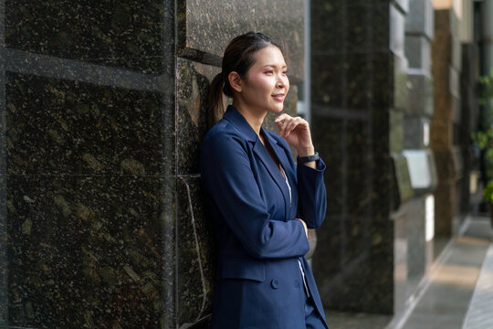 Confident Asian Businesswoman Looking Forward with Determination. Professional Corporate Portrait of Modern Executive in Urban Office Setting