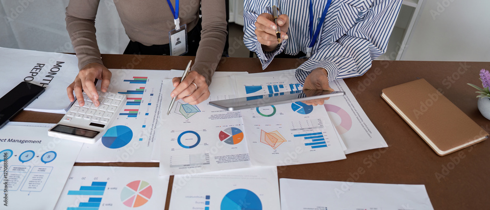 Poster financial analysts reviewing reports and strategies with digital tools in a modern workspace.