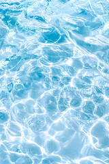 Obraz premium Water surface with sun reflections creating rippling abstract patterns, backdrop use