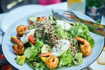 A plate with shrimp, lettuce leaves and avocado. Seafood salad
