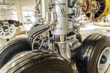 The aircraft's main rear landing gear. Shock absorbers, tie rods, and other complex mechanical parts are clearly visible. 
