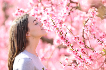 Woman smelling flowers in spring field