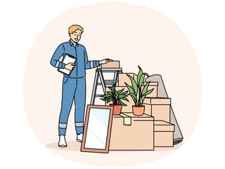 Man mover stands near pile of cardboard boxes advertising services of company that helps with moving to new home. Mover guy in blue uniform works in logistics business providing delivery services.