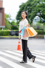 Joyful Shopper with colorful bags : A stylish individual strides confidently across a pedestrian...