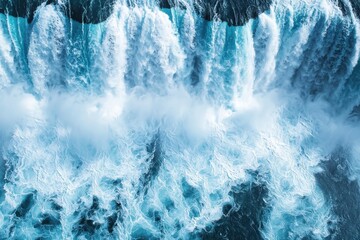 An aerial view of a powerful waterfall cascading down, showcasing the raw beauty and force of nature, with foaming water and vibrant blue hues.