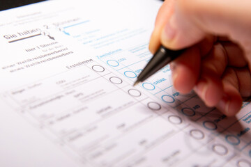 12. February 2025 - Berlin, Germany. Close up of a female hand marking a party on a ballot paper