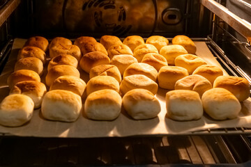 Freshly baked rolls cooling in an oven with golden brown crust