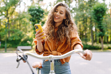 Happy woman commute with her bicycle and use phone in the streets happily. Travel, weekend, relax...