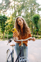 Happy woman commute with her bicycle and use phone in the streets happily. Travel, weekend, relax...