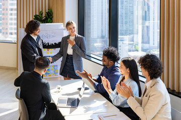 Team of diversity business people having agreement and handshake deal over new strategic strategy project on investment real estate with recognition and applause from other colleagues for partnership
