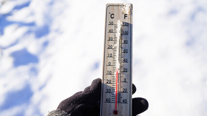 Thermometer on winter snow background. Thermometer for measuring outdoor air temperature. Cold...