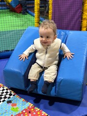 A baby boy playing and having fun in a soft play centre