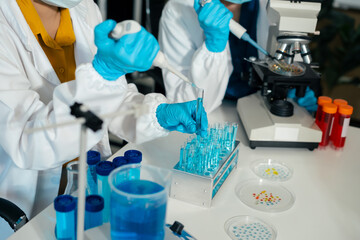 Fototapeta premium Medical or research scientist or doctor using looking at a test tube of clear solution in a lab or laboratory..