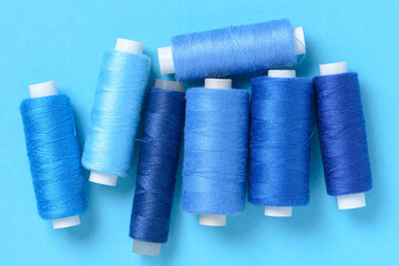 Blue thread spools background with copy space for text close-up flat lay top view
