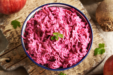 Vegetable salad made of fresh beetroot, apples and sour cream, top view
