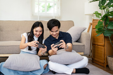 Obraz premium Couple gaming on the floor in a cozy living room, sharing laughter and playful competition.
