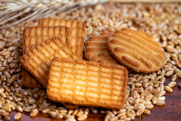 close up of biscuits grains, wheat flour and wheat ears on a wooden table backgrounds