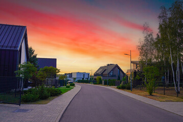 Street road on sunset at Suburban Scandi home. Contemporary barnhouse. Barn house on sunset. Barn...
