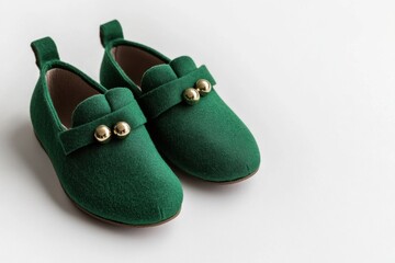 Adorable green baby shoes with gold button accents on white background