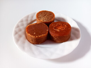 Coconut sugar aka coconut palm sugar, java sugar is a natural sweetener derived from the sap of the flower buds of the coconut tree isolated on white plate background.