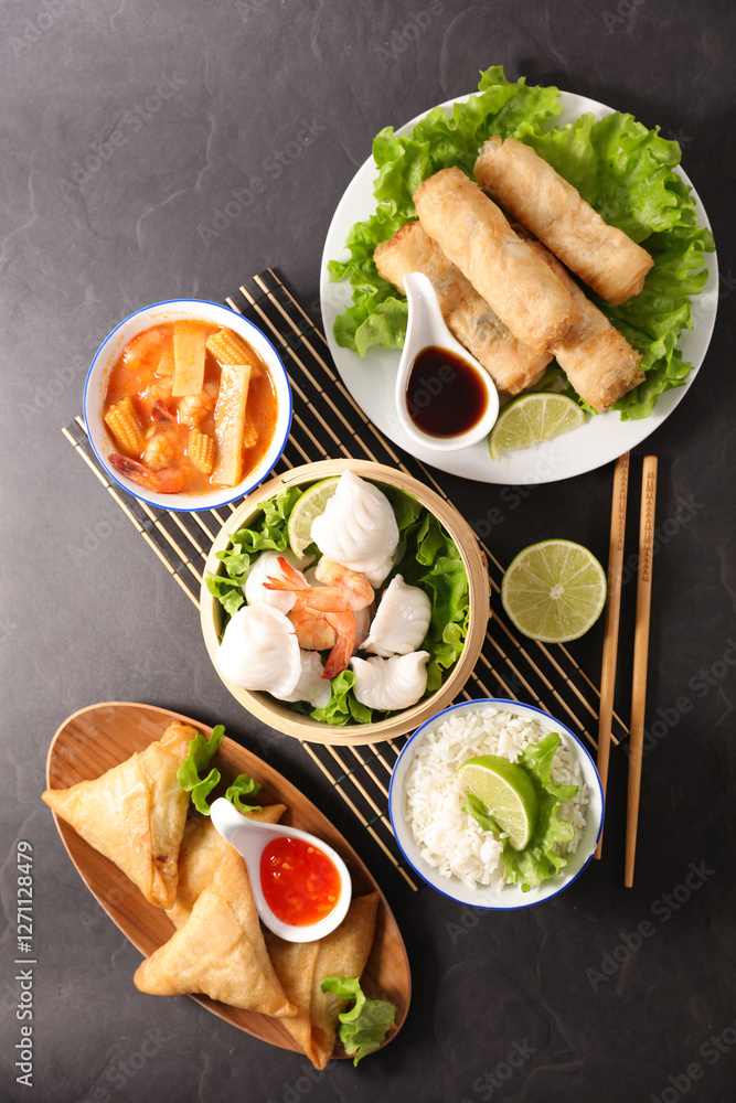 Wall mural Assortment of Asian Food - Spring Rolls, Samosas, Dumplings, and Rice