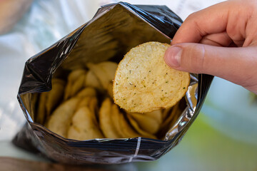 Crispy potato chips in aluminum metal bag package. concept of an unhealthy food and lifestyle. Bag...