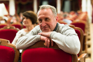 Elderly man watches a performance in a theater