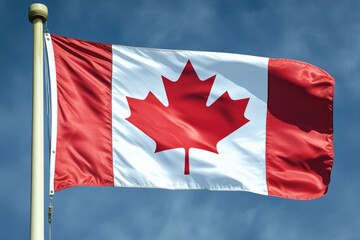 A Canadian flag waving in the wind against a bright blue sky