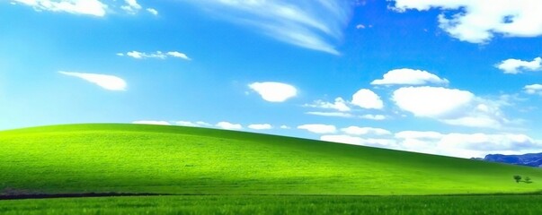 Obraz premium Soft focus of a blue sky over a rolling hill of green grass, calm, vast, nature