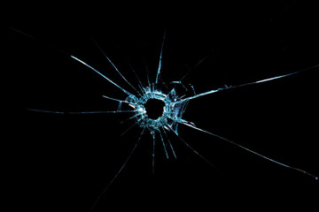 Cracks from broken glass fragments on a black background, the concept of destruction and instability
