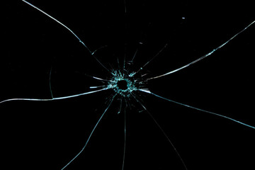 Cracks from broken glass fragments on a black background, the concept of destruction and instability
