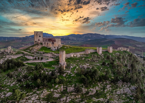 Aerial view of Castillo de la Estrella, Star castle in Teba Spain with large square keep dramatic colorful sunset sky