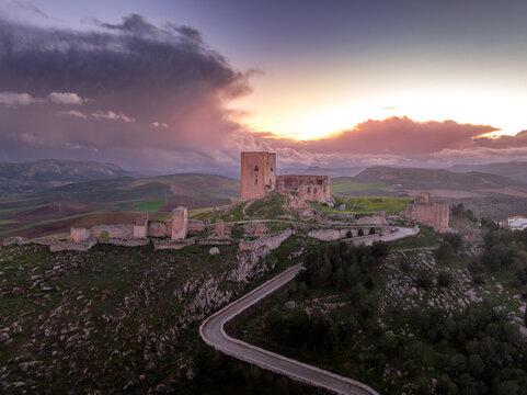 Aerial view of Castillo de la Estrella, Star castle in Teba Spain with large square keep dramatic colorful sunset sky