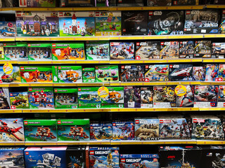 Naklejka premium Lviv, Ukraine - February 16, 2025: Colorful shelf display featuring LEGO themed sets from various series and franchises