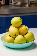 apples placed on a plate in the kitchen on a table
