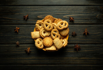 A colorful assortment of cookies sits attractively on a plate on a rustic wooden table before breakfast