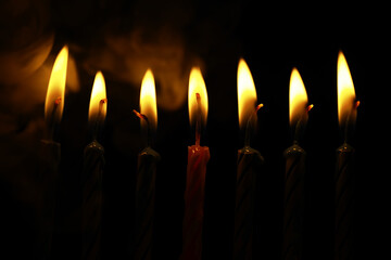 Close-Up of Several Lit Candles Against a Dark Background Creating Warm and Peaceful Light